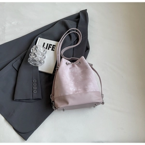 Detail view of pink bucket bag showing marble texture fabric and drawstring closure