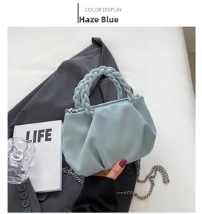 Detail view of mist blue pleated cloud bag with woven handle and silver chain strap