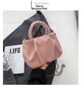 Detailed shot of pleated cherry blossom pink cloud bag with woven handle and chain