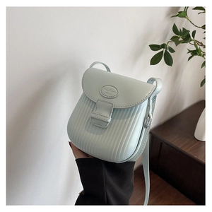 Detail showing vertical accordion pleats and embossed logo on mint green crossbody bag