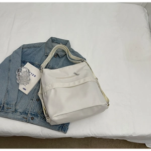 Detailed top view of a white large tote bag with zipper pockets and styling props