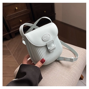 Detail view of light blue leather crossbody bag with pleated texture and buckle closure