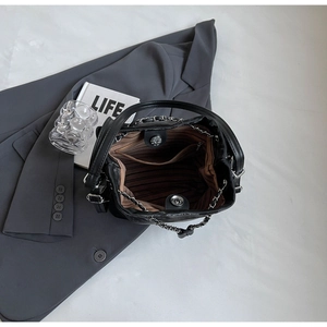 Top view showing the spacious interior of the black bucket bag with brown striped lining