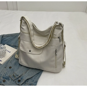 Detail view of cream white tote bag featuring functional front pocket with magnetic snap