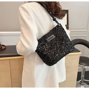 Detailed macro view of black sequined shoulder bag featuring a silver Fashion metal plate