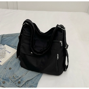 Top view of a black multi-pocket nylon shoulder bag with a silver metal zipper and wide strap