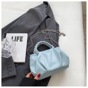 Detailed macro of a light blue pleated cloud bag with woven handle and silver chain strap