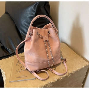Detailed view of pink drawstring bucket backpack with suede and leather texture