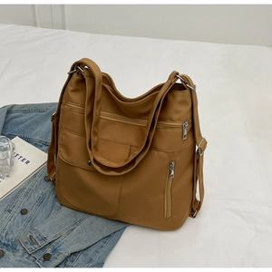 Close-up of deep camel nylon tote bag with multi-pocket details and adjustable shoulder strap