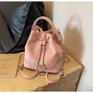 Detailed macro view of pink leather bucket bag with metallic chain and drawstring closure