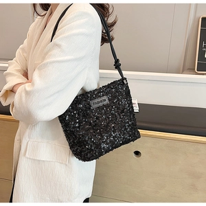 Detail of black sequined handbag featuring a FASHION leather label and sleek strap