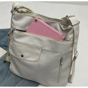 White multi-pocket tote bag showing spacious interior with a pink tablet inside