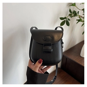 Detail of black crossbody bag with ribbed texture and embossed logo on the flap cover