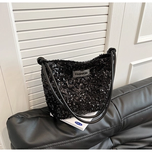 Detail of shimmering black sequin hobo bag with a 'FASHION' patch and elegant chain