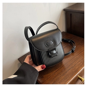 Detail of black crossbody bag featuring pleated texture and Fashion Bag logo plaque