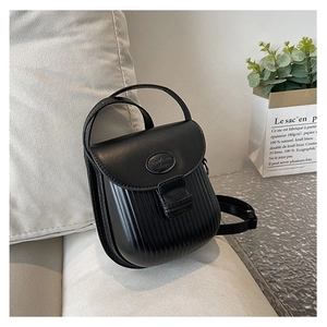 Detailed view of the vertical pleated texture and metallic logo on a black crossbody bag