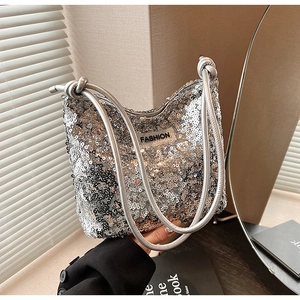 Close-up of silver sequined shoulder bag with drawstring straps and fashion label detail