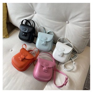 Close-up of five colorful mini crossbody bags featuring vertical embossed texture and flap design