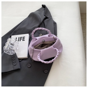 Detail of light purple pleated cloud bag featuring woven handles and silver rotary buckle