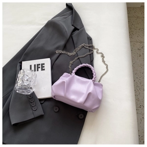 Detailed macro of a light purple pleated cloud bag with woven handle and silver chain strap