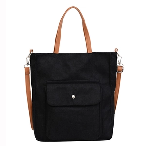 Ethnic linen tote bag in black fabric with brown faux leather straps and metal buckle
