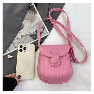 Pink mini crossbody bag with vertical texture showing compact size with a smartphone