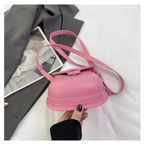 Detailed view of pink crossbody bag featuring vertical pleated texture and matching buckle