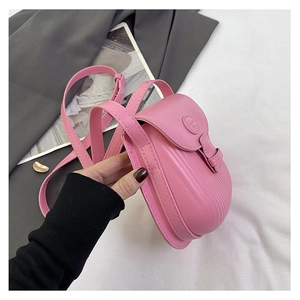 Detail of pink small crossbody phone bag featuring vertical texture and adjustable strap