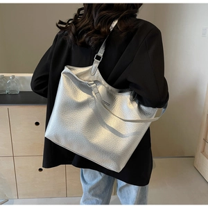 Silver metallic tote bag with pleated texture shown on model for a minimalist style look