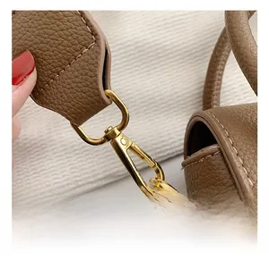 Vue détaillée du crochet doré et de la bandoulière en cuir marron à grain lychee