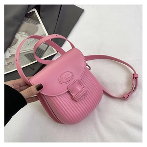 Detail of pink mini leather crossbody bag featuring vertical ribbed texture and fashion label