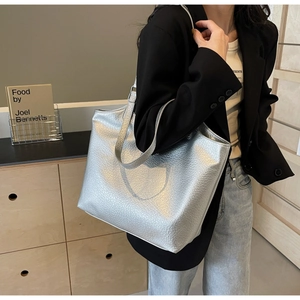 Close-up of the silver metallic leather texture and shoulder strap on a large tote bag