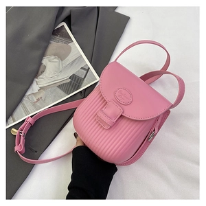 Detail view of pink textured leather crossbody bag with adjustable strap and silver metal parts