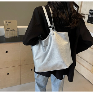Close-up of metallic silver tote bag featuring high-texture faux leather and metallic bar