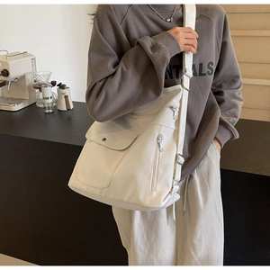 Detail of white large capacity PU shoulder bag featuring front buckle flap and side zipper pocket