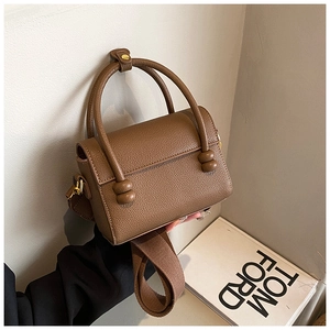Vue détaillée du sac à main marron à motif litchi avec quincaillerie dorée et sangle
