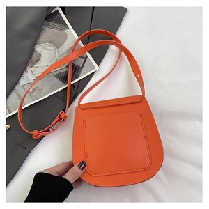 Detail view of the orange saddle crossbody bag with flat pocket and adjustable strap