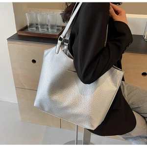 Detail of the silver metallic lychee pattern texture on the spacious commute tote bag