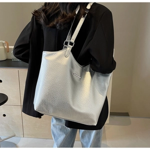 Silver tote bag made of high-quality lychee texture leather shown on a model's shoulder