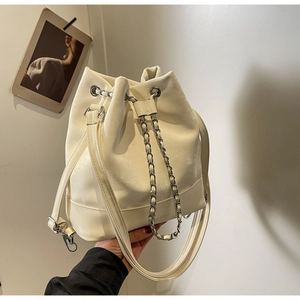 Close-up of cream bucket bag showing drawstring chain and LOVE & BAGS embossed logo