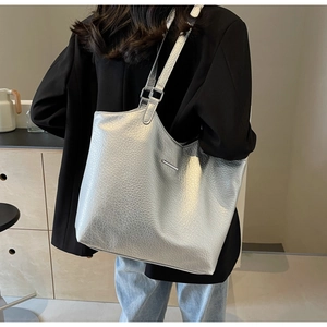 Close-up of silver tote bag showing its metallic texture and stylish shoulder strap detail