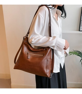 Borsa tote in pelle cerata marrone con zip metallica e tasca laterale indossata