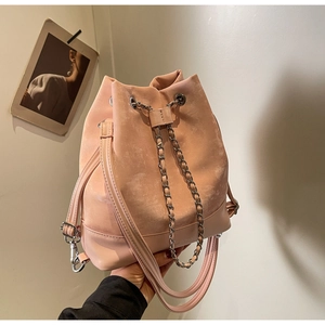 Pink drawstring bucket bag featuring silver chain detail and adjustable straps