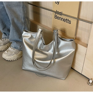 Detailed macro view of silver metallic textured faux leather tote with sleek metal trim