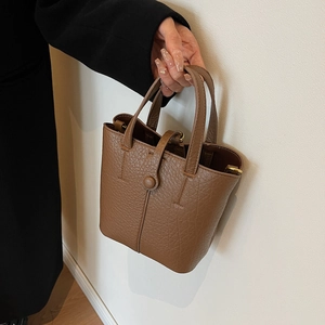 Brown litchi grain leather bucket handbag with twin handles and golden D-ring hardware