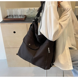 Detailed view of black large-capacity nylon shoulder bag with functional multi-pockets