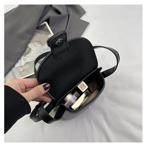 Detailed interior view of a black leather crossbody bag showing space for cosmetics