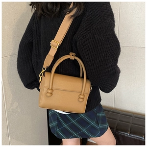 Sac bandoulière marron clair porté par un mannequin pour montrer le style et la taille
