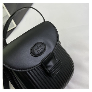Detail of black mini crossbody bag with vertical striped pleats and Fashion Bags logo tag