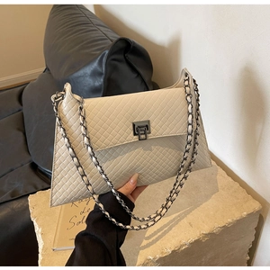 Detailansicht der cremeweißen gesteppten Tasche aus PU-Leder mit Metalldrehverschluss und Kette